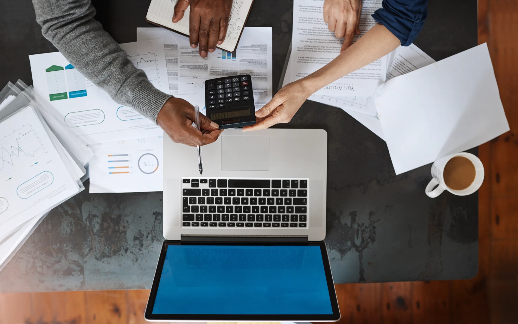 Business paperwork, calculator and laptop during a financial planning discussion