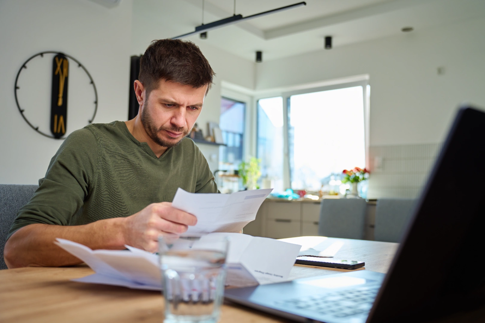 Canadian taxpayer reviewing financial paperwork at home with a laptop